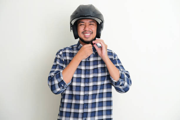 istock Adult Asian man smiling while tighten his motorcylce helm strap 1400016839