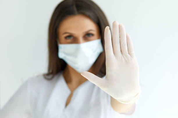 istock Help stop spreading globally coronavirus pandemic infectious disease outbreak. On background woman in mask focus on stretched hand as symbol of keep distance avoid communication 1400018022