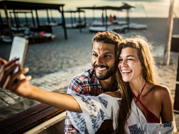 istock Happy couple taking a selfie with smart phone on the beach. 1400018712