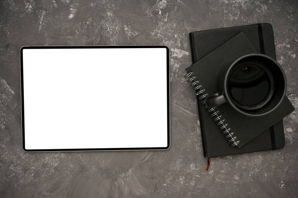 istock Digital tablet mockup, black coffee cup and black notebook on modern grey background. 1400020152