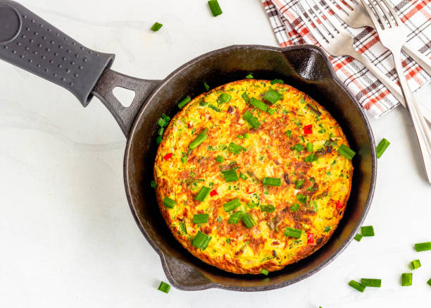 frittata / omlete na żeliwnej patelni na białym tle zdjęcie z góry na dół - omelet breakfast eggs onion zdjęcia i obrazy z banku zdjęć