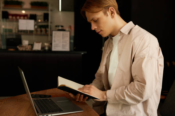 istock Distance Education. Young black bearded student learning online at the bar, looking at laptop and taking notes 1400021306
