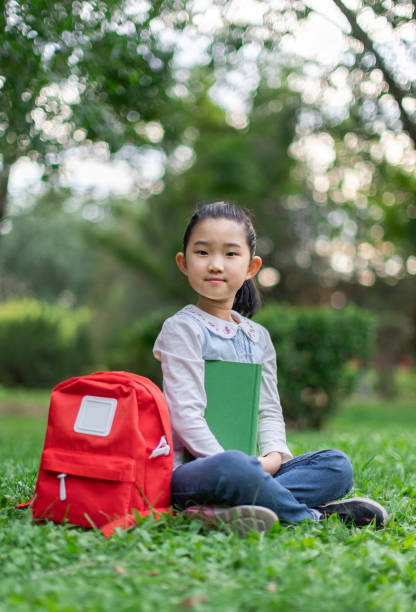 istock Little Girl Reading Book on Lawn 1400023239