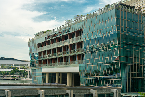 Daytime view of the Fullerton Hotel main building with balconies and windows, located in Marina Bay Area