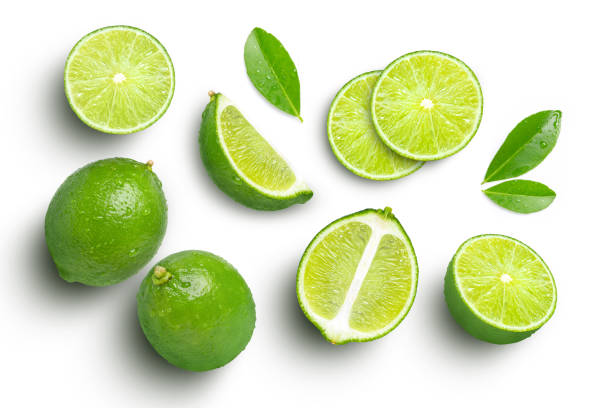 frutos de lima con hoja verde y cortados en media rodaja aislados sobre fondo blanco - lime wedge fotografías e imágenes de stock