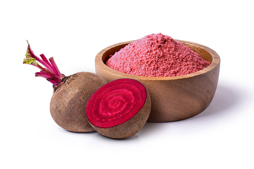 Beetroot (beet root) powder in wooden bowl with fresh fruit isolated on white