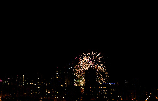 Colorful fireworks over the city. Amazing holiday fireworks party or any celebration event in the dark sky.