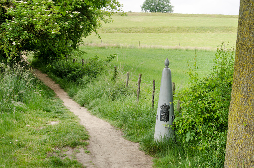 Slenaken, The Netherlands, May 29, 2022: old steel border stone along a footpath, indicating the border between Belgium and the Netherlands