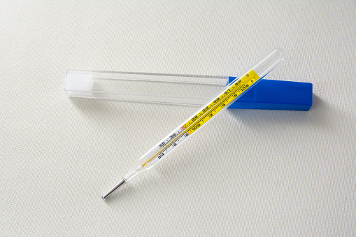 Medical mercury thermometer on white background.