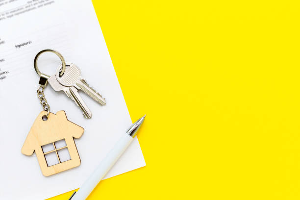 집 모양의 열쇠 고리와 부동산 담보 대출 서류에 펜, 새 주택을 구입하고 건설하기위한 계약 계약, 보험, 임대 또는 임대 아파트. 노란색 배경, 복사 공간 - loan mortgage document house real estate 뉴스 사진 이미지