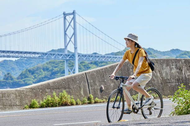 uma mulher japonesa que gosta de andar de bicicleta no shimanami kaido - short cycle - fotografias e filmes do acervo