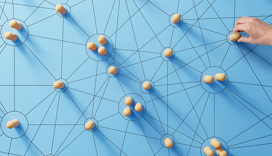 Redes sociales. Red con miembros conectados entre sí. Grupo de personas. Comunicación, trabajo en equipo, comunidad, sociedad. Concepto abstracto con piezas de madera sobre fondo azul. photo