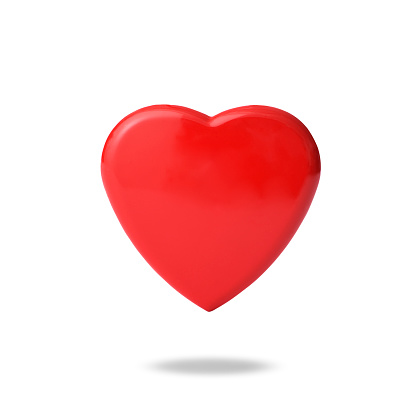 Close-up of red heart shaped metal floating in mid-air against white background.
