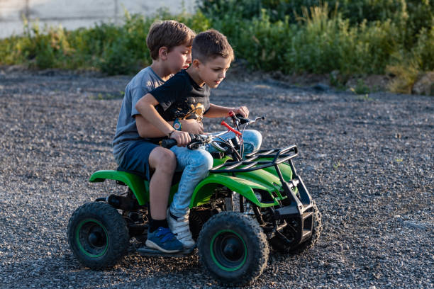 Two brother riding a green quad motor