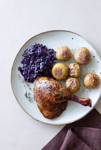 istock Baked duck leg with potatoes and red cabbage. 1400032707