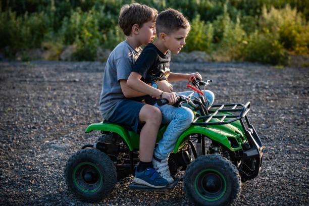 Two little brothers on green quad bike