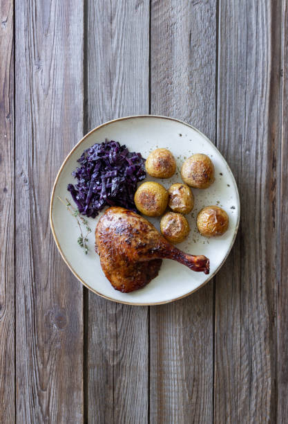 istock Baked duck leg with potatoes and red cabbage. 1400033367