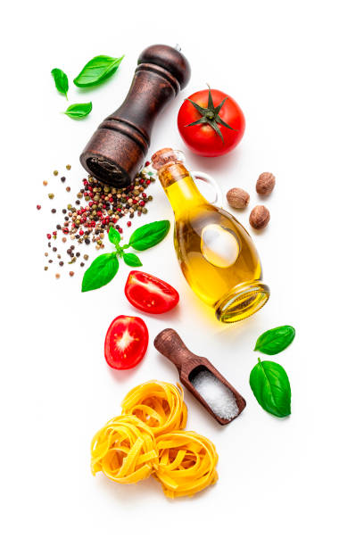 Top view of various Italian ingredients such as pasta, basil, tomatoes, pepper, olive oil and nutmeg on isolated on white background.