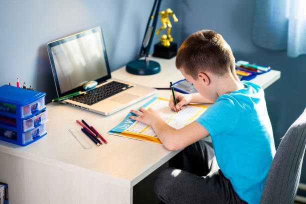 istock Boy sitting at the desk doing homework at home. 1400040641