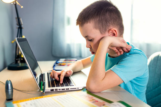 istock Boy sitting at the desk doing homework at home. 1400040928