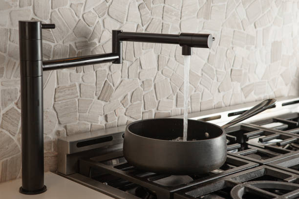 Black pot filler faucet over stove stock photo