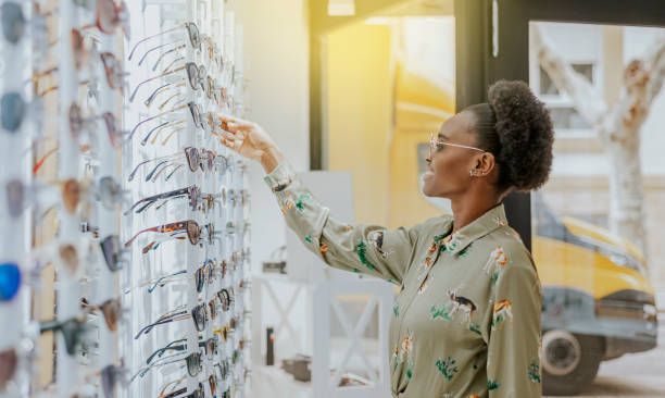 A young African-American girl looking at glasses in an optician's shop stock photo