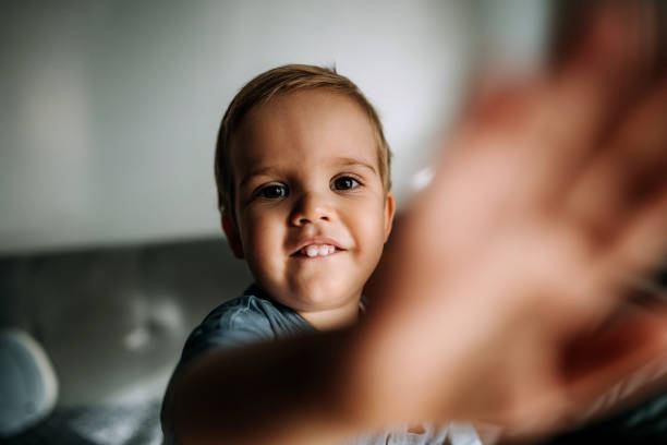istock Cute little smiling boy reaching for camera 1400043747
