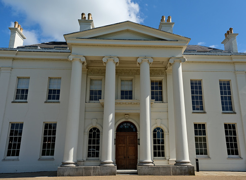 Public Hylands park and grounds with Georgian or Regency neo classical stately house villa or Palladian mansion. Brigerton or Sandition style. Outdoors on a Summers day. Chelmsford, Essex, United Kingdom, May 28, 2022