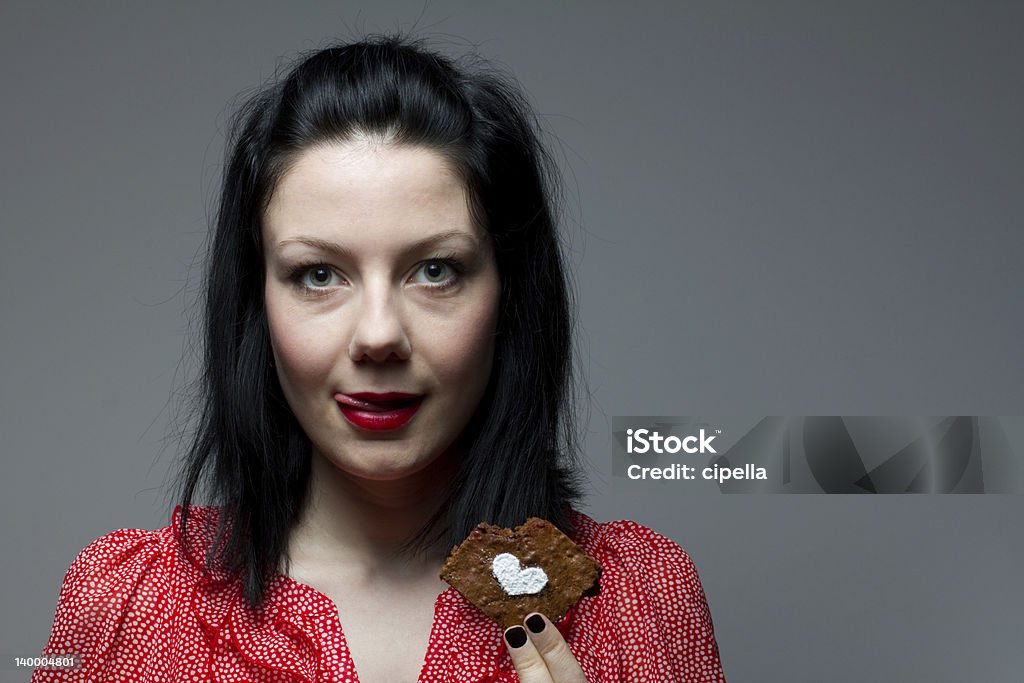 Jovem mulher comer o brownie - Royalty-free Lamber os Lábios Foto de stock