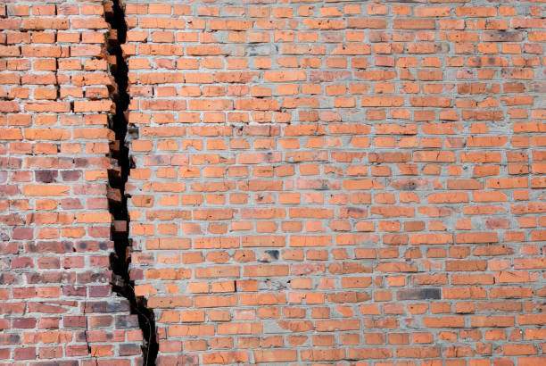 Red brick wall with huge black crack