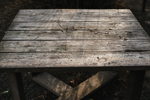 Old table in the garden. Grunge background with place for text, on a background of gray untreated table boards.