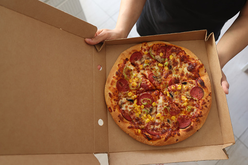 Woman holding pizza box