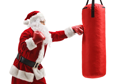 Santa claus boxing a punching bag isolated on white background