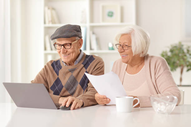 istock Happy elderly man and woman holding a document and looking at a laptop computer 1400051830