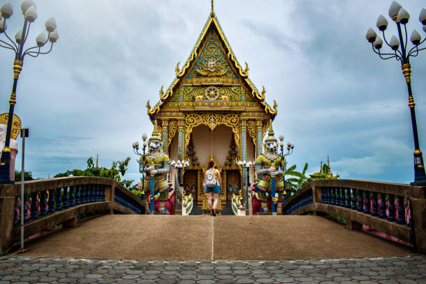 Young tourist walking in Thai temple. Tourist walking in Thailand. Young woman visiting  Koh Samui Thailand