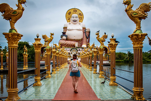 Young tourist walking in Thai temple. Tourist walking in Thailand. Young woman visiting Big Buddha Koh Samui Thailand