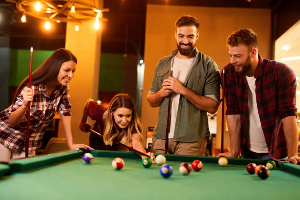 istock Group of friends having fun while playing pool in a local pool hall 1400052886