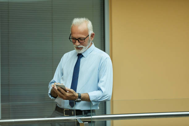 istock Portrait of an elderly businessman using mobile phone 1400054220