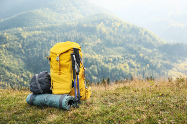 istock Backpack, trekking poles and sleeping mat in mountains, space for text. Tourism equipment 1400056356
