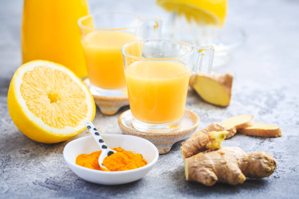 close up of healthy ginger lemon turmeric shot - ideal to boost the immune system - orange smoothie imagens e fotografias de stock