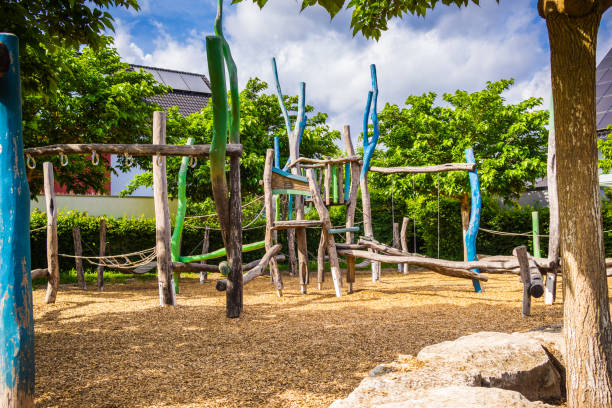 Empty public playground on sunny day with play equipment made from wood