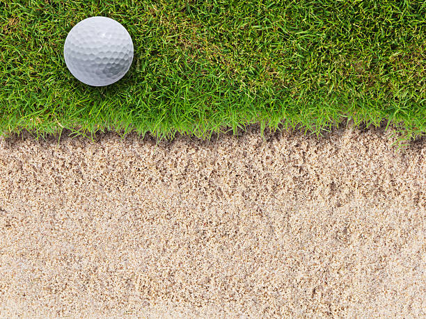 balle de golf sur vert herbe près de bunker - sand trap golf sand trap photos et images de collection