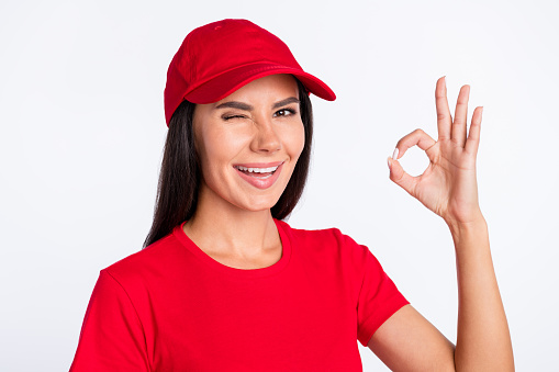 Photo of young happy smiling lovely charming service girl showing okay sign wink eye isolated on grey color background.