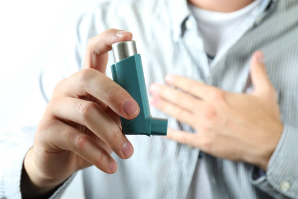 istock Young man holds asthma inhaler during asthma attack 1400058980