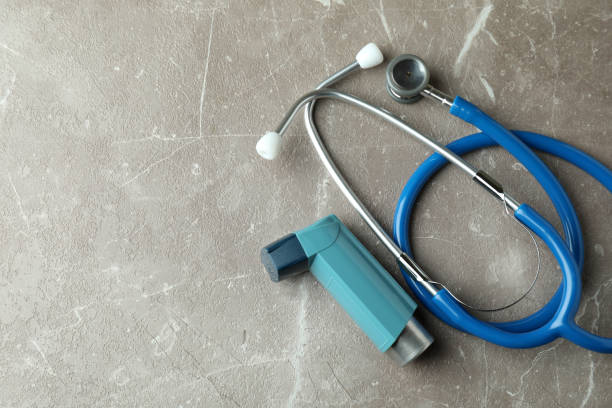 istock Asthma inhaler and stethoscope on gray textured table 1400059175