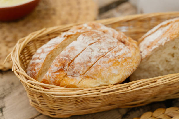 istock Freshly baked sliced ​​bread in a wicker basket on the table. 1400059739