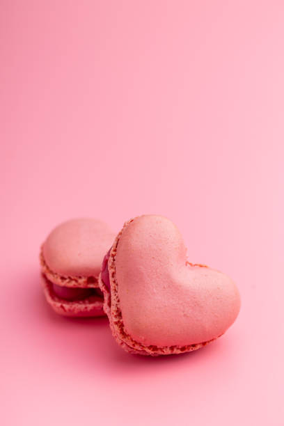 istock Heart shaped Sweet macarons on pink background. 1400059742