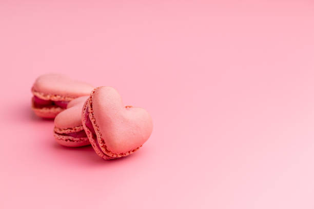 istock Heart shaped Sweet macarons on pink background. 1400059762