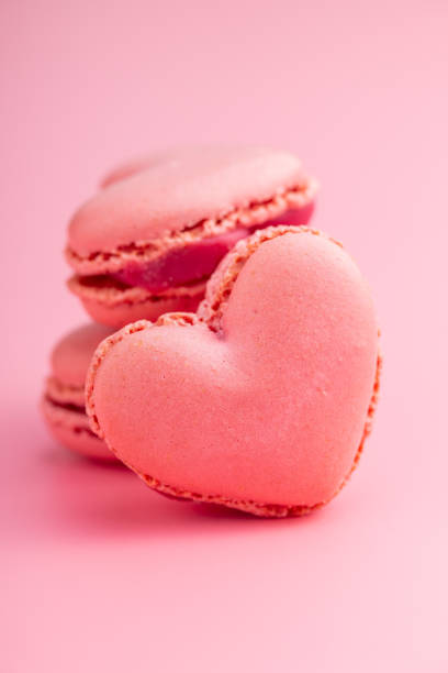 istock Heart shaped Sweet macarons on pink background. 1400059764