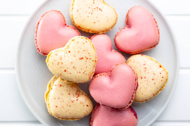 istock Heart shaped Sweet macarons on white table. 1400060313